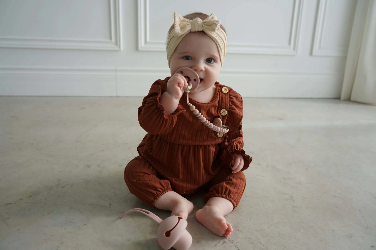 Enfant avec attache-suce et suce rose